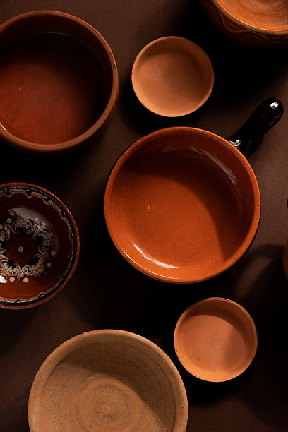 istock Arrangement of ceramic plates on brown background. Earthenware pottery objects, space for text. 2214844362