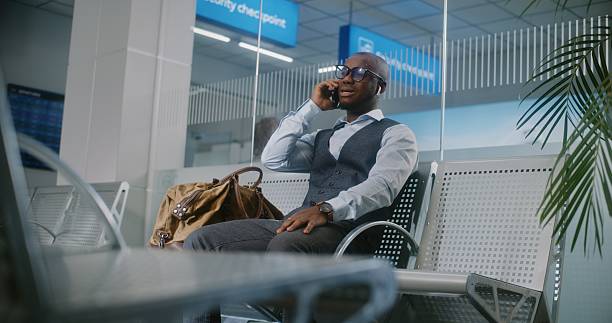 istock Airport Terminal: Businessman Talking on Cellphone to Business Partner 2214844500