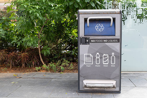 Singapore, Singapore - May 01, 2025: A recycling bin located on Orchard Road in Singapore, featuring clear instructions for waste disposal, surrounded by lush greenery and urban elements