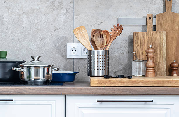 istock Kitchen countertop with utensils, pans on induction hob, bowls, cutting boards. 2214845688