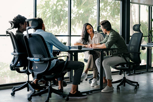 Group of young multi-ethnic startup business team collaborating on project in modern office. Young successful start-up entrepreneurs working as a team together.