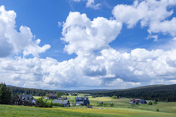 Jizera Mountains landscape with typical houses enriching the valley under blue sky with cumulus clouds