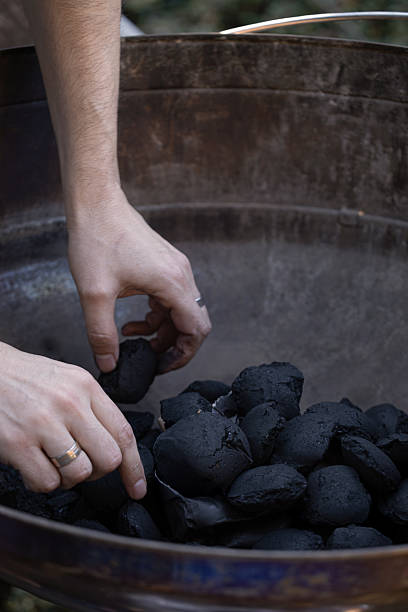 istock Hands arranging charcoal briquettes in barbecue grill 2214847141