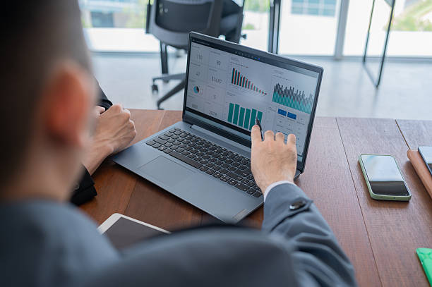 istock Close up Asian Chinese employees discussion using laptop showing chart in office stock photo 2214847607