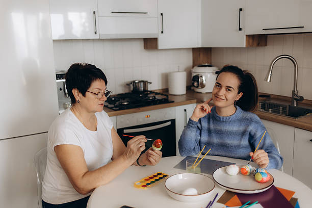 istock Mother and Daughter Painting Easter Eggs in a Bright Modern Kitchen 2214849403