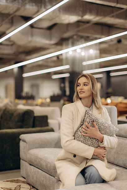 istock Woman Exploring Comfortable Sofas and Cushions in Modern Furniture Store 2214850267