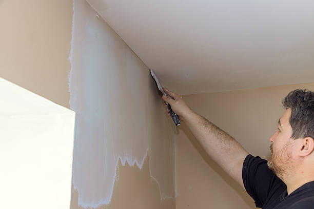 istock Man applying plaster to a wall corner in a home renovation project during daylight hours 2214850421