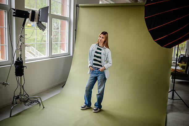 istock Young woman poses confidently in a photo studio setting with creative lighting and backdrop for a fashion shoot 2214855775