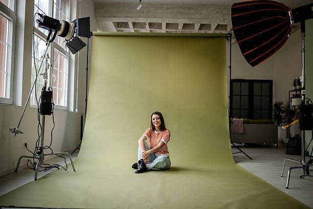 istock Young woman poses confidently in a photo studio with creative lighting and backdrop during a fashion photo shoot 2214855976