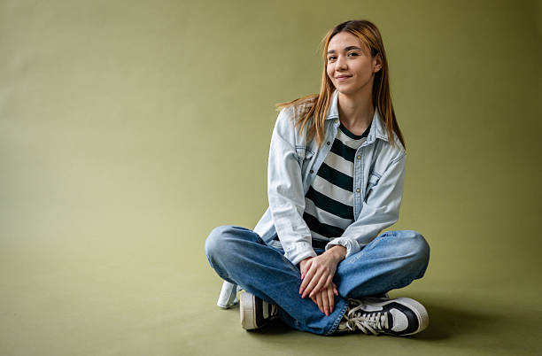istock Young woman poses confidently in a studio setting, showcasing fashion and creativity during a photo shoot 2214856370
