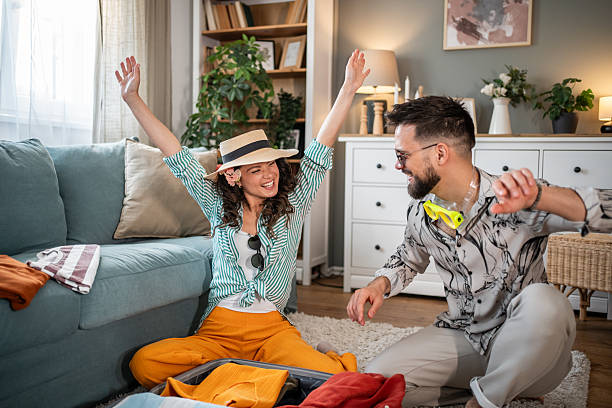 istock Young couple packing suitcase for summer vacation and having fun 2214860370