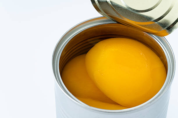 istock Canned yellow peaches against a white background 2214860561