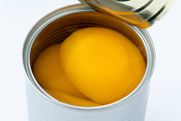 istock Canned yellow peaches against a white background 2214860615