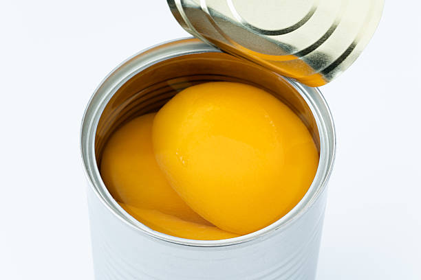 istock Canned yellow peaches against a white background 2214860674