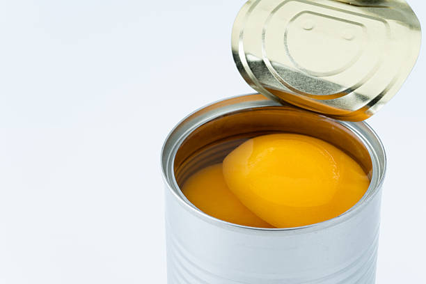 istock Canned yellow peaches against a white background 2214860763