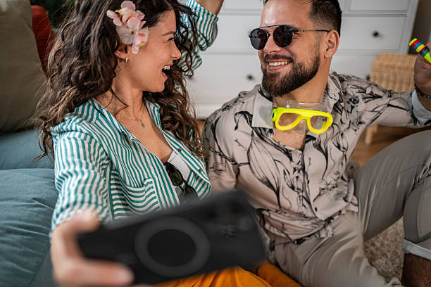 istock Couple taking a selfie while wearing summer clothes and accessories indoors 2214860957