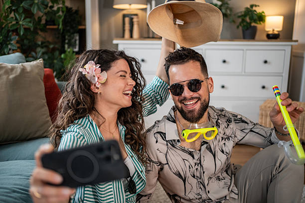 istock Enthusiastic couple taking a selfie with summer accessories, planning their vacation 2214860961