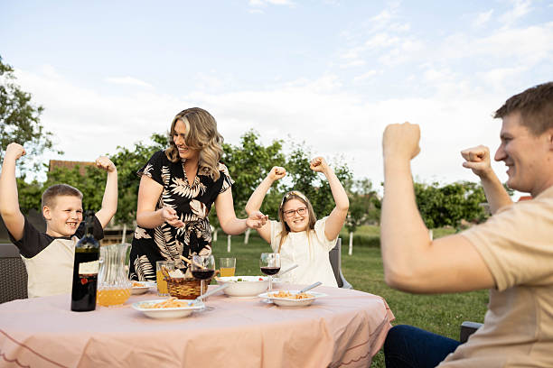 istock Family having fun flexing muscles at outdoor lunch 2214866720