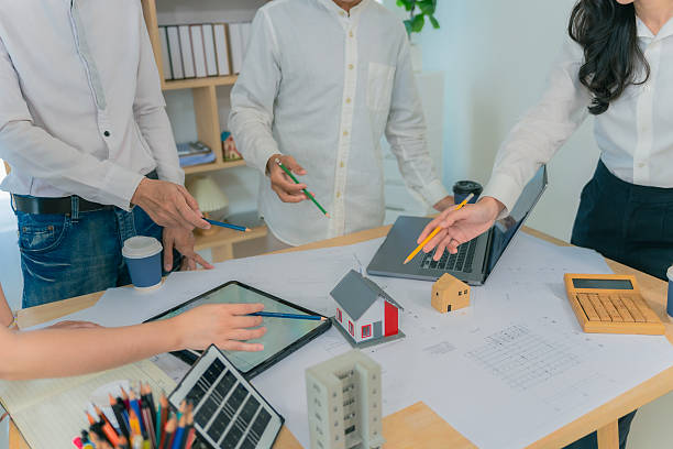 istock Business construction concept architect or engineer discussing with construction blueprint at table. Engineer inspecting workplace to plan architecture. Drafting construction project. Close up. 2214868454