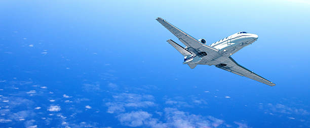 istock Private jet flying over a cloudy ocean on a sunny day 2214870013