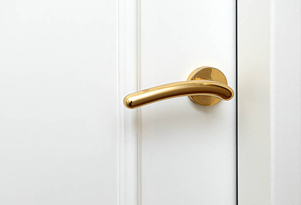 istock Golden door handle on a white door representing elegance and style 2214870025