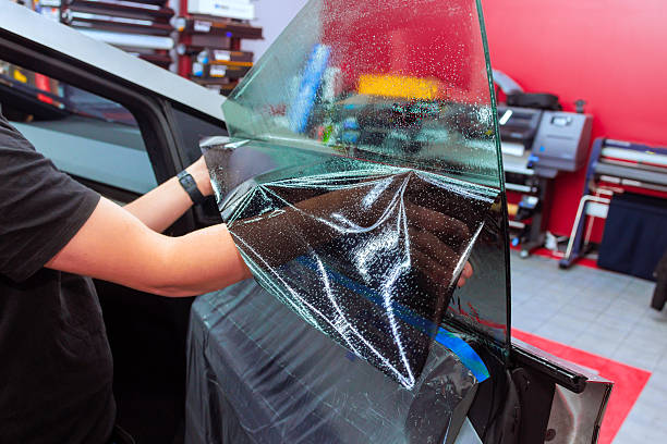istock Professional window tinting process in a workshop using high quality film for vehicle enhancement project 2214870176