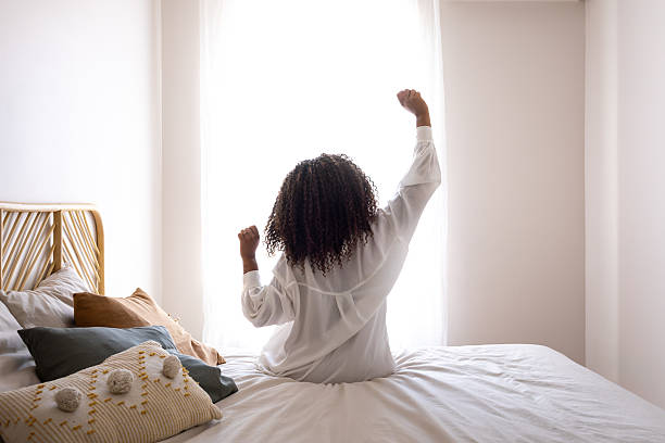 istock Young woman stretching in bed after waking up 2214871136