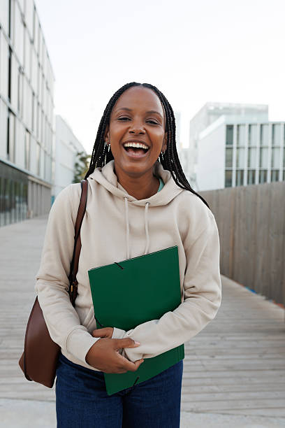 istock Cheerful university student smiling and holding a folder 2214871202