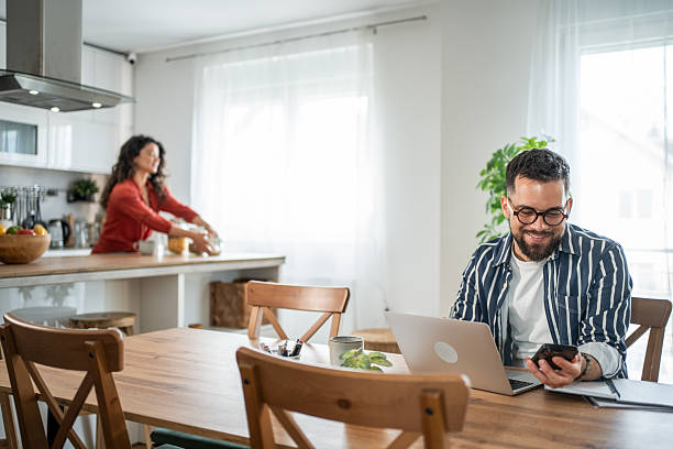 istock Young man working from home while his wife is cooking 2214872367