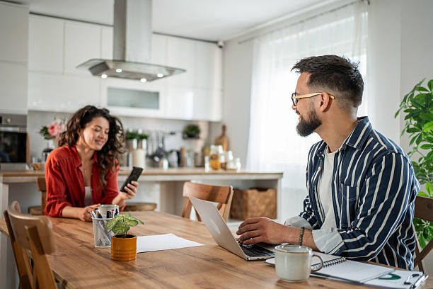 istock Young man working from home while his wife is cooking 2214872418
