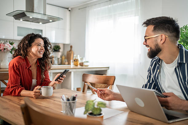 istock Couple working from home having fun while using laptop and smartphone 2214872438