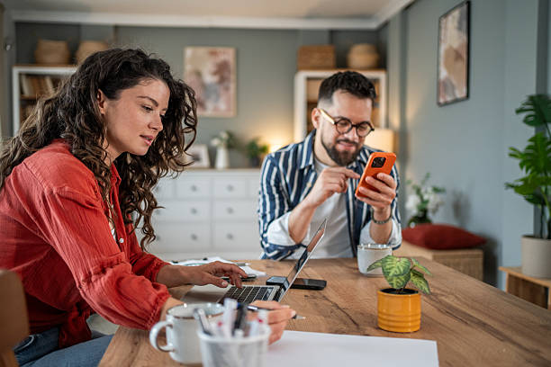 istock Young couple working from home using laptop and smartphone 2214872468