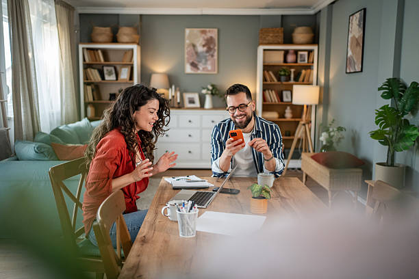 istock Young couple working from home having fun with smartphone 2214872505