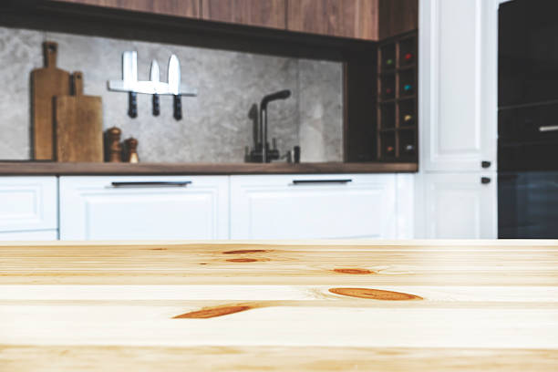 istock Blurred white and wood kitchen interior with wooden table, modern classic, with induction hob, black sink and furniture fittings, wine bottle holder, knife magnet, kitchen utensils and cookware. Real photo 2214873293