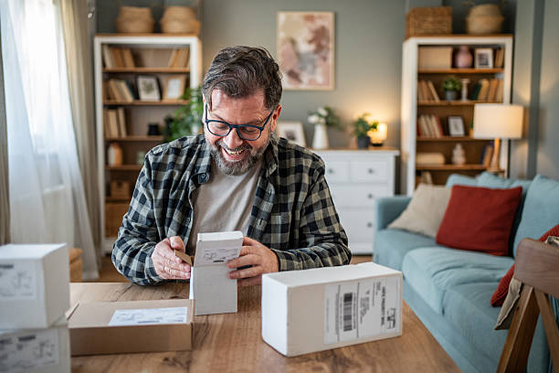 istock Happy small business owner opening packages at home office 2214874936