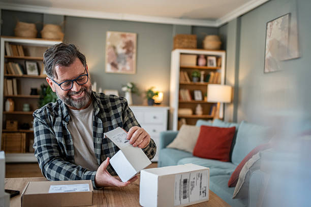istock Happy mature man opening a package at home 2214875085