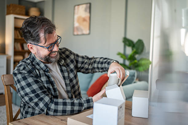 istock Happy mature man unpacking parcels at home 2214875096