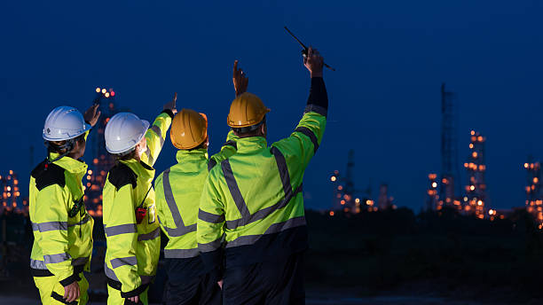 istock caucasian white engineers in safety uniforms and helmets using laptop and radio for site communication. Concept of teamwork, inspection, and operations at an industrial facility.Construction of Oil, Gas and Fuels Transport Pipeline,Pipe Manufacturing Fact 2214876251