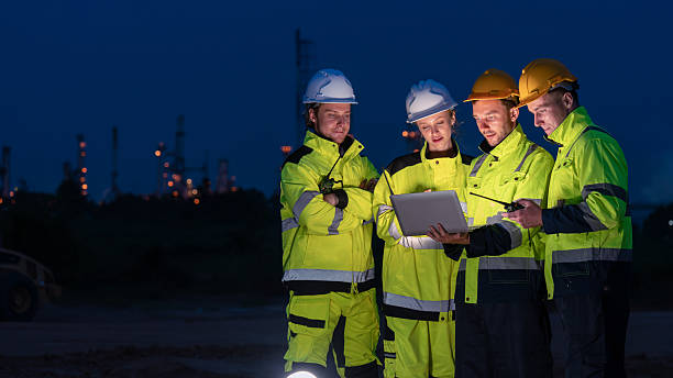 istock caucasian white engineers in safety uniforms and helmets using laptop and radio for site communication. Concept of teamwork, inspection, and operations at an industrial facility.Construction of Oil, Gas and Fuels Transport Pipeline,Pipe Manufacturing Fact 2214876342