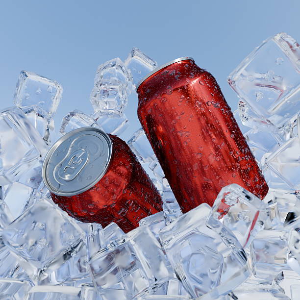 istock Two red soda cans sit amidst sparkling ice cubes, reflecting sunlight. The bright blue sky provides a perfect summer backdrop, enhancing the refreshing scene. 3d render 2214877322