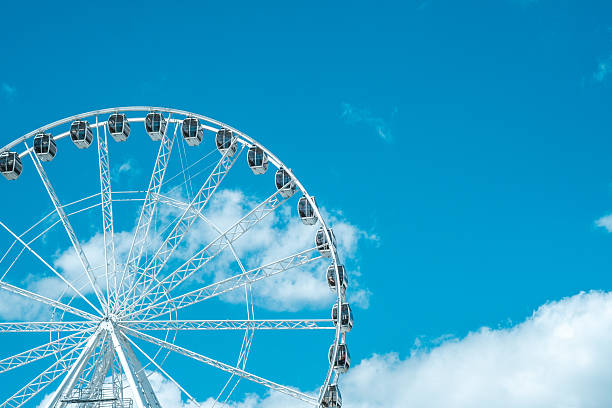 istock A large white ferris wheel under a bright blue sky with fluffy white clouds and clear weather 2214877456