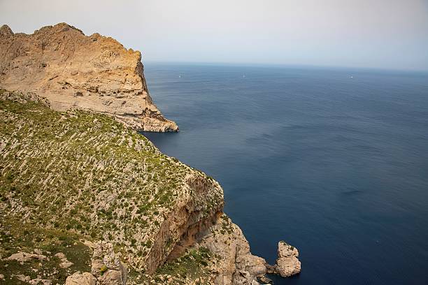Aerial view of Cala Deia Cove in Mallorca, Spain, captured by drone. The photo shows turquoise waters, rocky cliffs, and the stunning natural surroundings of this Mediterranean cove. Ideal for travel, tourism, and scenic photography, highlighting the beauty and serenity of Mallorca’s coastline.