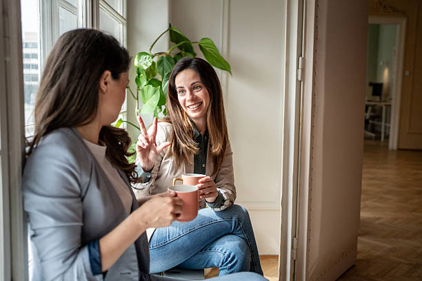 istock Two businesswomen enjoying coffee break and chatting by window 2214879390