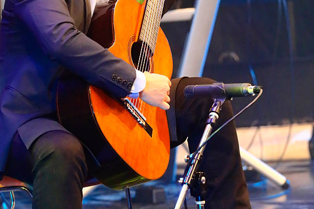 Thai man playing acoustic guitar on stage