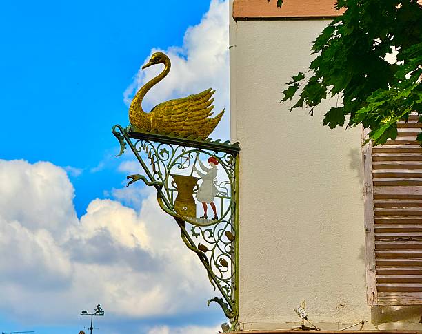 traditional street lighting with a detail from the coat of arms of the city of Lisbon with the 23-metre-high plinth with the bronze statue of Dom Pedro IV in the background; Lisbon, Portugal
