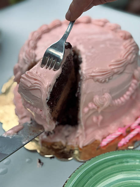istock Fork Lifting a Slice of Chocolate Layer Cake with Pink Icing 2214887043
