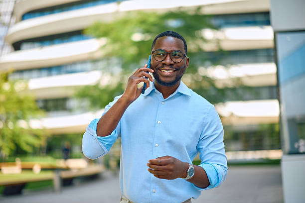 istock Smiling businessman talking on smartphone in front of office building 2214889201
