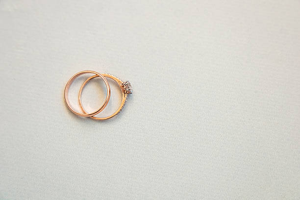 istock Elegant gold and diamond wedding rings arranged on a soft surface in a well-lit setting 2214891848