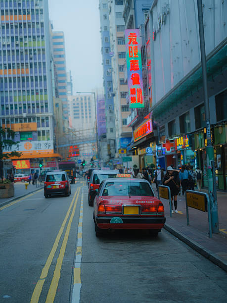 Iconic red taxi on the crowded street in  Hong Kong