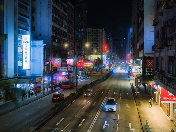 Traffic on illuminated with neon lights road in Hong Kong at night